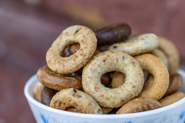 Freshly baked mini bagels on a dark background. Top view. Pretzels in the form of a ring close-up. Small bread circle biscuit. Bowls with different types of bagels.