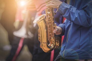 Musical instruments in a marching band, saxophone playing hands, saxophone playing jazz. Alto saxophone, musical instrument, close-up.