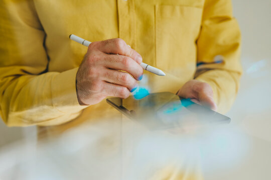 Hand using stylus on digital tablet showcasing innovation and technology