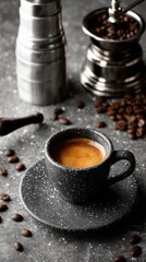 A cozy scene of coffee preparation is showcased with a black cup of espresso, coffee beans, and a grinder all situated on a saucer, highlighting rich textures