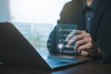 Businessman checking virtual task checklist on laptop using stylus. Digital approval interface with...