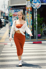 A beautiful teenage model girl posing on the streets of old town during street style photo shooting