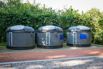 Three Modern Urban Waste Bins on Brick Pavement