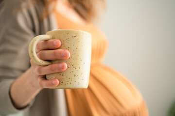Mom-to-be savoring warm coffee drink in peaceful home setting. Responsible caffeine intake...