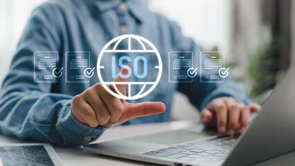 Businessman using digital interface for ISO certification and compliance verification, showing approved documents for quality control and standardization.