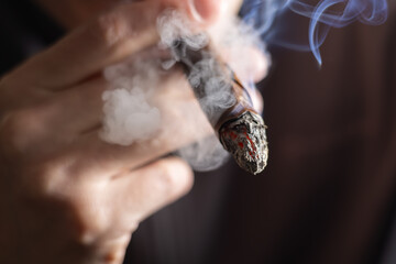 Man holding a cigar in his hand close-up