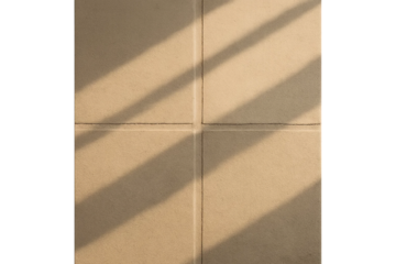 Terracotta floor tiles in warm sunlight casting diagonal shadows across four square sections with white grout. Tile with grout and transparent background
