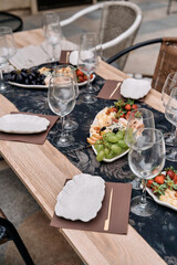 An Elegant Dining Setup Featuring a Beautiful Spread of Fresh Fruits and Gourmet Delicacies Arranged on a Stylish Table with Fine Glassware