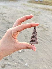 Fingers Holding a Triangular Piece of Ancient Pottery