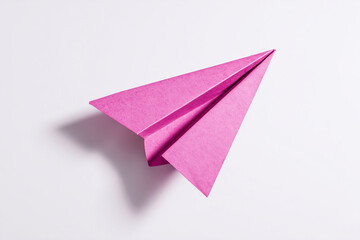 Pink paper aeroplane on white background