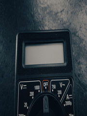 A hand holding a digital multimeter for electrical work