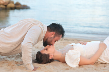happy couple on the beach. Pregnant girl in white dress. Pregnancy