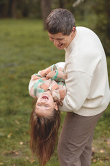 Naklejka premium dad and daughter playing in autumn park. autumn. father's day. fatherhood