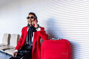 Stylish non-binary person talking on phone while waiting at airport