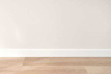 Neutral white textured wall with natural light, beige wooden floor and skirting board, empty template for home room interior product backdrop, background for branding design showcase, copy space