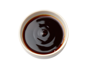 Close up of dark soy sauce inside a small white ceramic dish isolated on black background