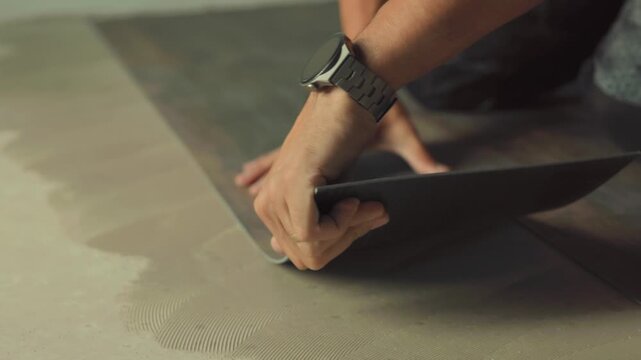 Construction worker installing luxury vinyl plank flooring