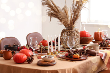 Autumn table setting with pumpkins, pampas grass and pine cones