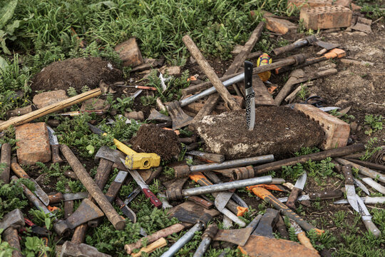 View of a collection of axes, knives, and hammers scattered amongst bricks and dirt clods, used for the Sky Burial in the Langmu Monastery, in Sichuan, China.