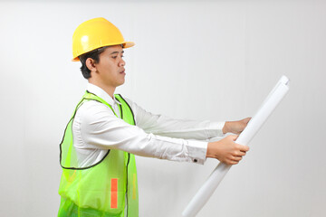 A construction worker holds a blueprint in his hand, looking intently at a detailed drawing of a building isolated on a white background. Conceptual engineering and business work