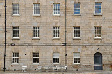 The imposing stone facade of the historic Collins Barracks in Dublin, now part of the National Museum of Ireland. The building features a symmetrical arrangement of three rows of windows 