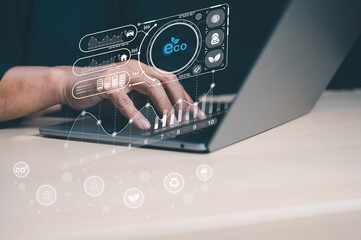 A hand typing on a laptop with eco-themed graphics, illustrating technology's role in promoting sustainability and environmental awareness.