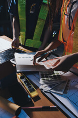 Closeup of team of industrial engineers meeting analyze machinery blueprints consult project on table in manufacturing factory. Working in manufacturing plant or production plant.