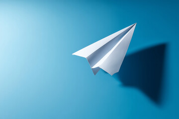 white paper aeroplane on blue background