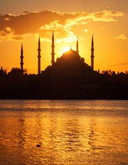 Fototapeta premium Silhouette of a mosque at sunset over water
