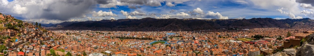 Panoramic view of Cusco cityscape with mountains.