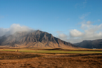 Fototapeta premium Snowy peaks reflect in a serene mountain lake at sunrise, a breathtaking natural Nordic landscape in Iceland