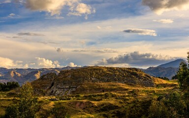 Scenic view of rocky hill under cloudy sky.