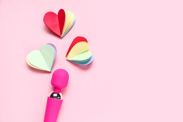 Fototapeta premium Vibrator with colorful paper hearts on pink background. LGBT concept