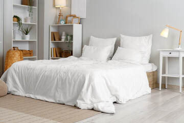 Interior of light bedroom with shelf units and glowing lamps