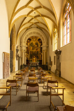 View of a golden altar glows warmly under vaulted ceilings and stained glass in the church interior, inviting quiet contemplation, Graz, Styria, Austria.