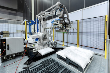 Sack gripper on industrial robot arm in production line manufacturer factory.