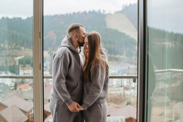 Young couple sharing a tender moment on balcony with mountain view
