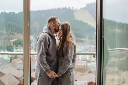 Young couple sharing a tender moment on balcony with mountain view