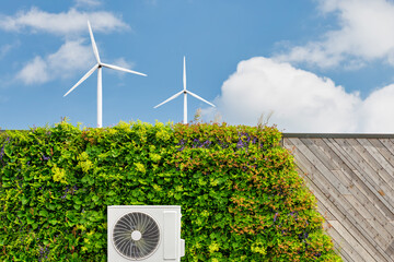 Air-source heat pump on a green sustainable building with vertical plants and wind turbines © Martin Bergsma