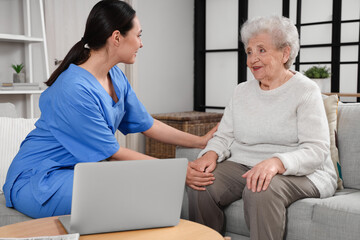 Obraz premium Physical therapist taking care of senior woman at home