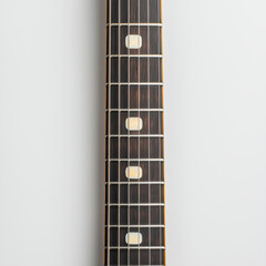 Close up of electric guitar neck with strings and fretboard, showcasing its intricate design and craftsmanship