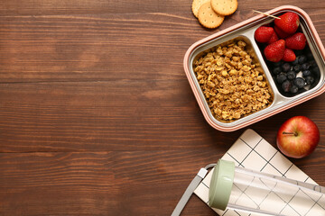 Lunch box with tasty food, bottle of water and notebook on wooden background