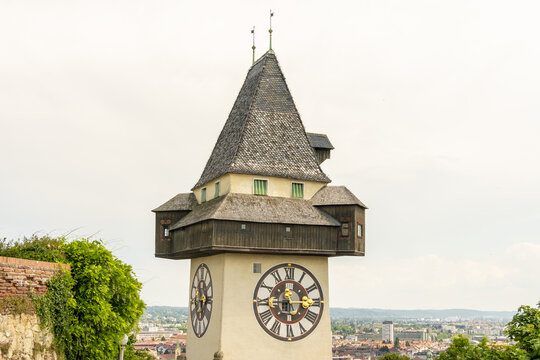 View of the ancient clock tower, a historic monument with a steeple and clock face, standing tall against the skyline, Graz, Styria, Austria.