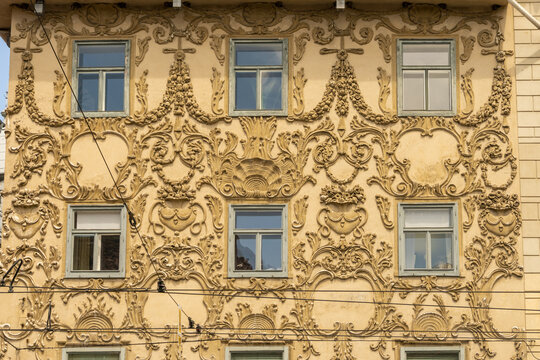 View of a building facade adorned with intricate baroque ornamentation and symmetrically aligned windows, Hauptplatz, Graz, Austria.