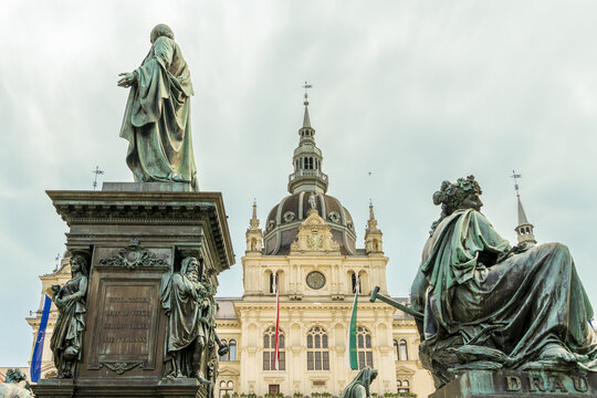 View of the Archduke Johann Fountain, a majestic bronze sculpture with classical figures, contrasting against the ornate Graz City Hall, Graz, Graz, Austria.