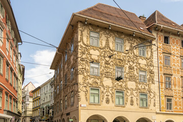 View of ornate buildings with intricate facades under a bright sky, showcasing detailed architectural designs, Hauptplatz, Graz, Austria.