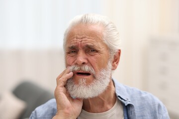 Fototapeta premium Senior man suffering from toothache at home