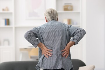 Senior man suffering from back pain at home