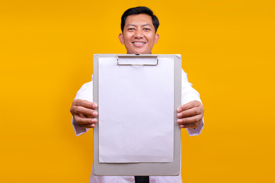 Young Asian Male Doctor Showing Test Result On White Blank Clipboard