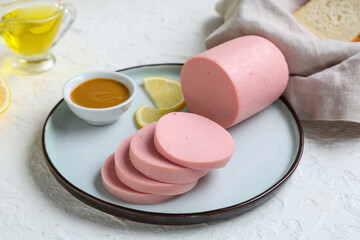 Sliced bologna sausage with mustard and lemon on plate, deli meat for sandwiches and breakfast, white background © Pixel-Shot